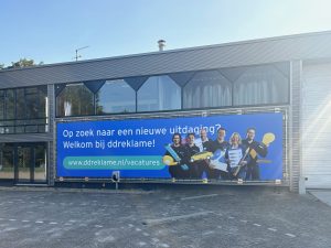 blauw spandoek met witte tekst
