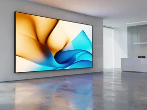 Groot digitaal displayscherm op kantoorwand met amber en blauw licht weerspiegeld op gepolijste betonvloer.